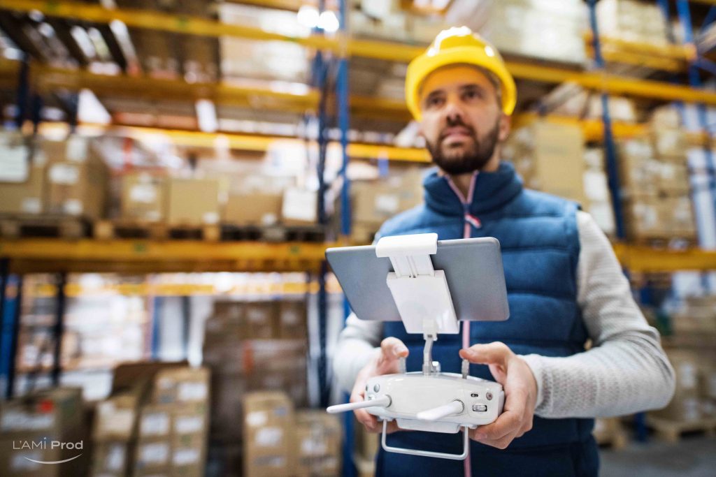 Man or a worker with tablet and drone controller standing in a warehouse.